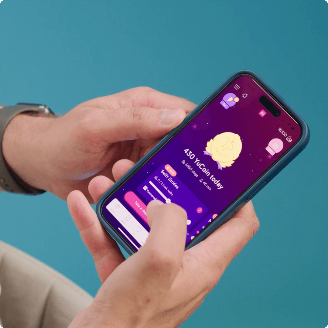 An action shot of a person holding a phone looking at the YuScreen in the YuLife app. 